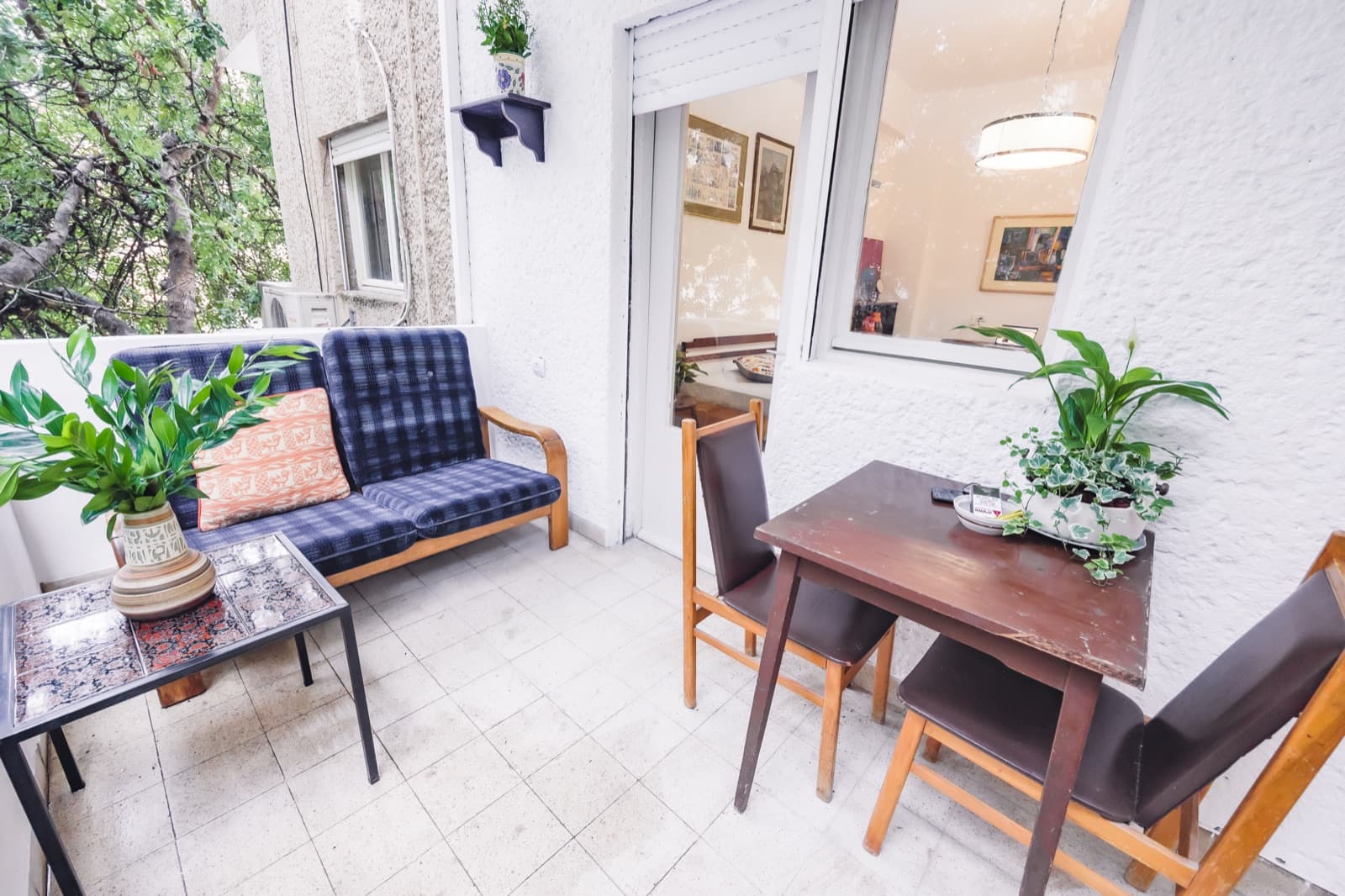 Front balcony with dining table and lounge bench at the apartment near the Bahá’í Gardens, Haifa