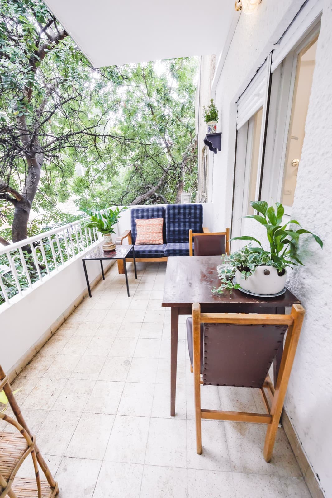 Leafy private balcony with sofa bench overlooking the trees of Hadar HaCarmel, Haifa